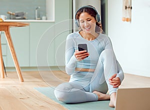 Beautiful young mixed race woman listening to music while taking a break from practicing yoga at home. Hispanic female