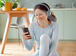 Beautiful young mixed race woman listening to music while taking a break from practicing yoga at home. Hispanic female