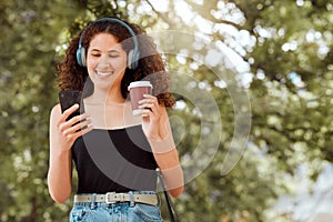 Beautiful young mixed race woman listening to music and texting on her phone outside. Confident and happy african