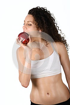 Beautiful young mixed woman eating an apple, isolated on white