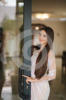 Beautiful young model in evening drees posing to photographer inside big restaurant