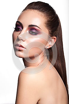 Beautiful young model with evening make up, perfect skin and nude lips. Trendy colorful smoky eyes