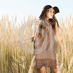 Beautiful young model passing tallgrass meadow - outdoors shot photo