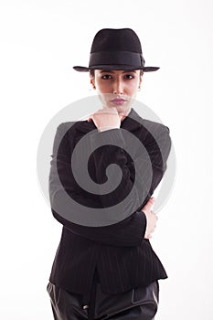 Beautiful young model posing in studio with a retro hat wearing a stylish black jacket