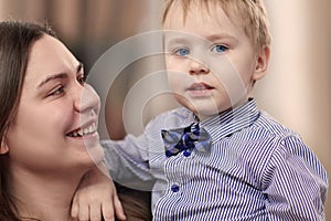 Beautiful young mother with a baby boy in her arms at home. Happy family and motherhood concept.