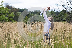 Beautiful young mother with a baby girl in flower field