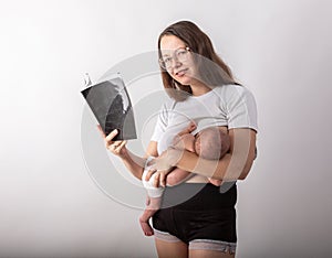 Beautiful young mother breastfeeding a baby while reading a black book