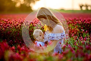 Beautiful young mother, breastfeeding her toddler baby boy in go