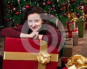 Naughty woman leans on a huge box with a New Year gift