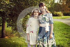 Beautiful young mother in a floral dress and daughter teen 10 ye