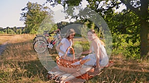 Beautiful young mother having picnic with her daughter next to a lake