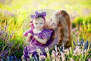 Beautiful young mother and her daughter having fun at the lavender field. Mothers Day