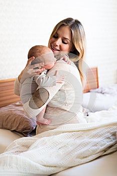 Beautiful young mother holding baby son in her arms