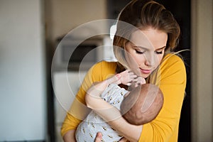 Beautiful young mother holding baby son in her arms