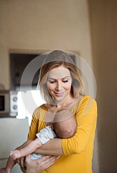 Beautiful young mother holding baby son in her arms