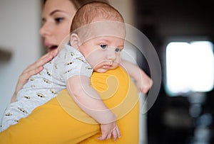 Beautiful young mother holding baby son in her arms