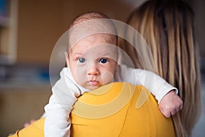 Beautiful young mother holding baby son in her arms