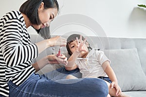 Beautiful young mother is painting the nail varnish to her cute little daughter