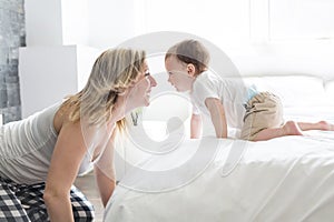 Beautiful young mother and son lying together on a bed