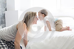 Beautiful young mother and son lying together on a bed