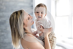 Beautiful young mother and son lying together on a bed