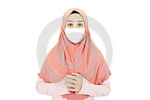 Beautiful young muslim asian woman with traditional dress wearing medical face mask isolated on white background