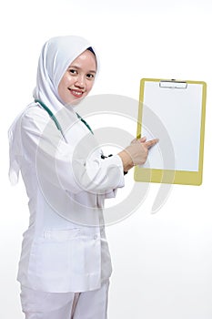 Beautiful young muslim woman nurse or doctor pointing the blank paper at clipboard