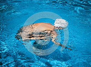 Beautiful young nude woman in swimming pool