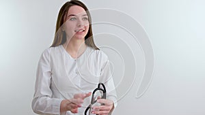 Beautiful young nurse or doctor with stethoscope stands, looking to the right side wearing blue scrubs