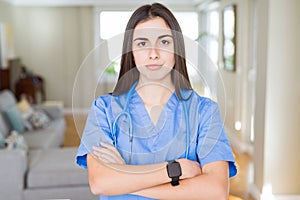 Beautiful young nurse woman wearing uniform and stethoscope at the clinic skeptic and nervous, disapproving expression on face photo