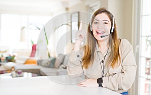 Beautiful young operator woman wearing headset at the office pointing finger up with successful idea