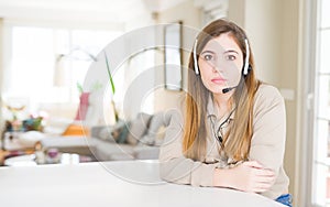 Beautiful young operator woman wearing headset at the office with serious expression on face