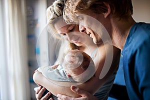 Beautiful young parents with a newborn baby at home.