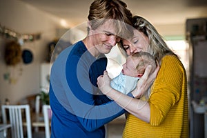 Beautiful young parents with a newborn baby at home.