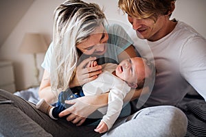 Beautiful young parents with a newborn baby at home.