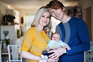 Beautiful young parents with a newborn baby at home.