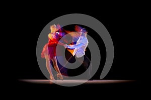 Beautiful young people, man and woman dancing tango, ballroom over black background with mixed neon lights. Concept of