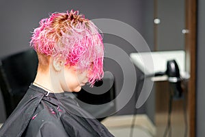 Beautiful young pink haired caucasian woman in the modern hair salon.