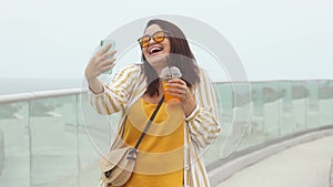 Beautiful young plus size woman 30-35 years old takes a selfie on her phone