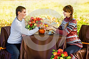 Beautiful Young Pregnant Couple Having Picnic in autumn Park. Ha