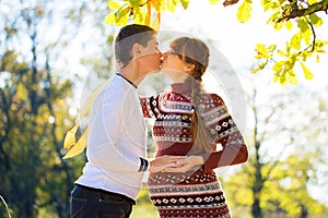 Beautiful Young Pregnant Couple Having Picnic in autumn Park. Ha