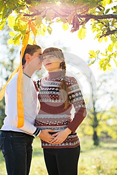 Beautiful Young Pregnant Couple Having Picnic in autumn Park. Ha