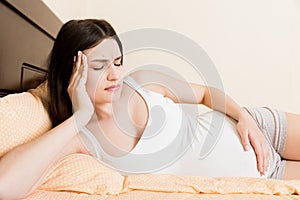 Beautiful young pregnant woman lying in bed, top view. the girl suffers from the fact that her husband left her