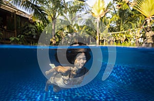 Beautiful young pregnant woman underwater in swimming pool split photography.