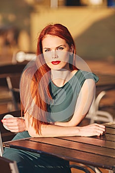 Beautiful young red-haired woman in green dress