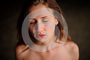 Beautiful young redhead girl in the water cave with closed eyes