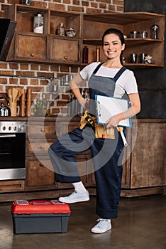 beautiful young repairwoman with tools and clipboard