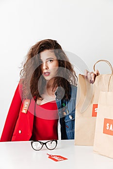 Beautiful young sale woman sitting with paper shopping bags