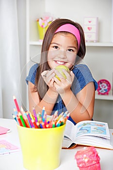 Beautiful young school girl eating an apple