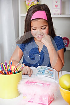 Beautiful young school girl reading a book